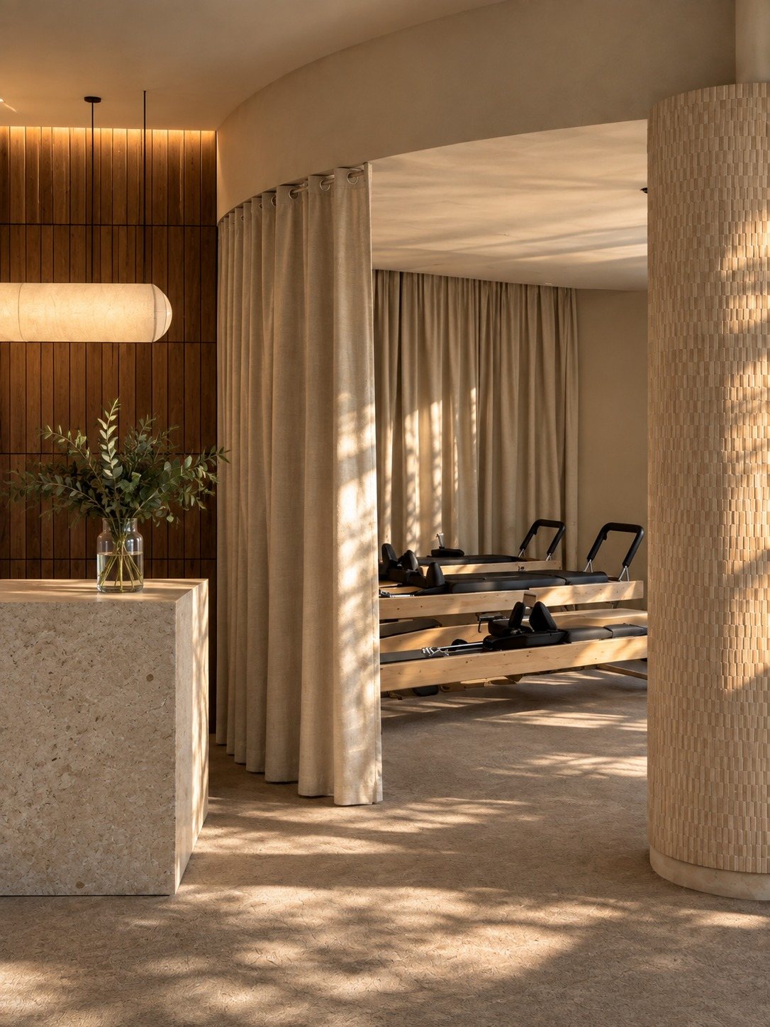 Akasa Studio, Dubai — sala de pilates con cortinas translúcidas y columna curva