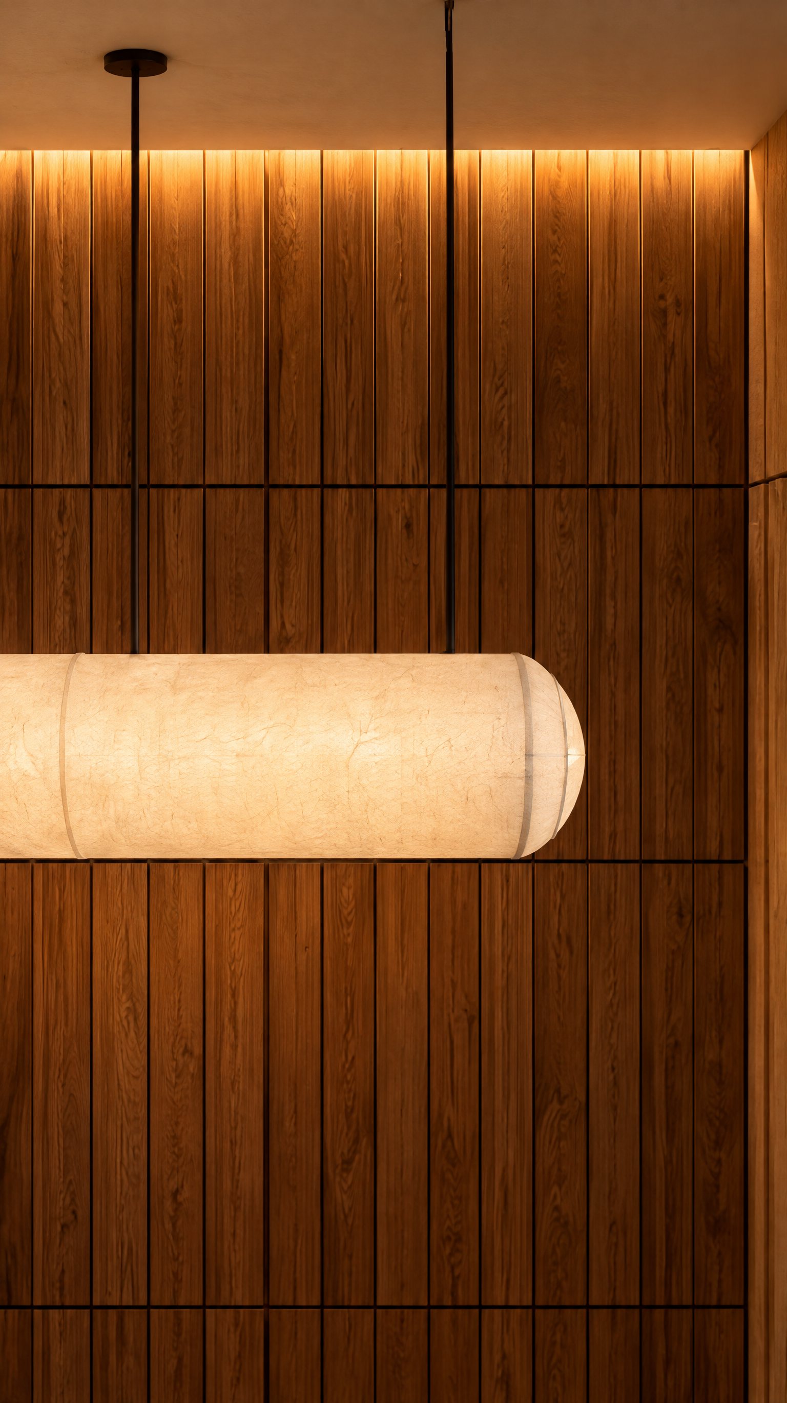 Akasa Studio — Lámpara de papel sobre panelado de madera iluminado