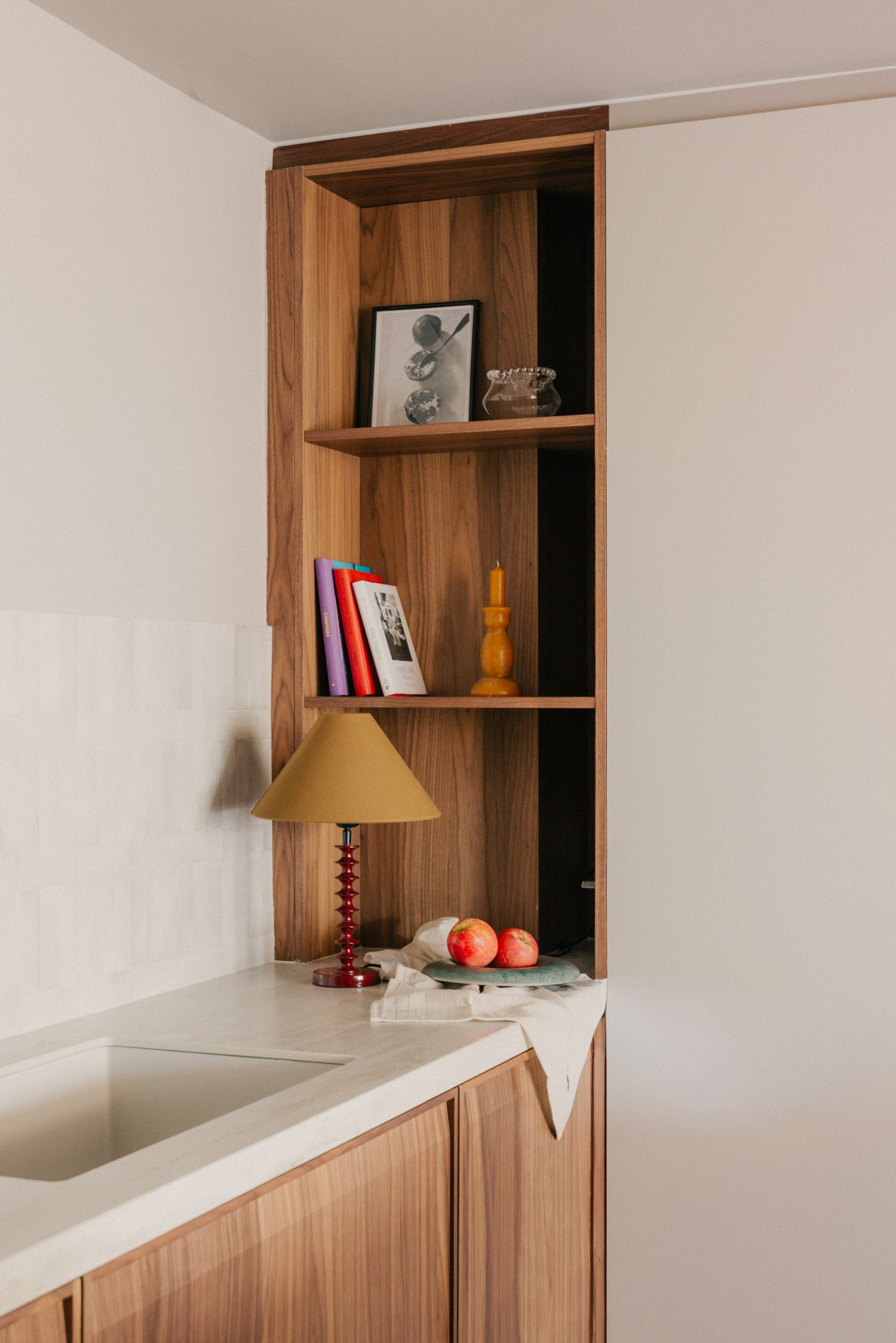 Casa Manila — Rincón de cocina con estantería de madera y lámpara