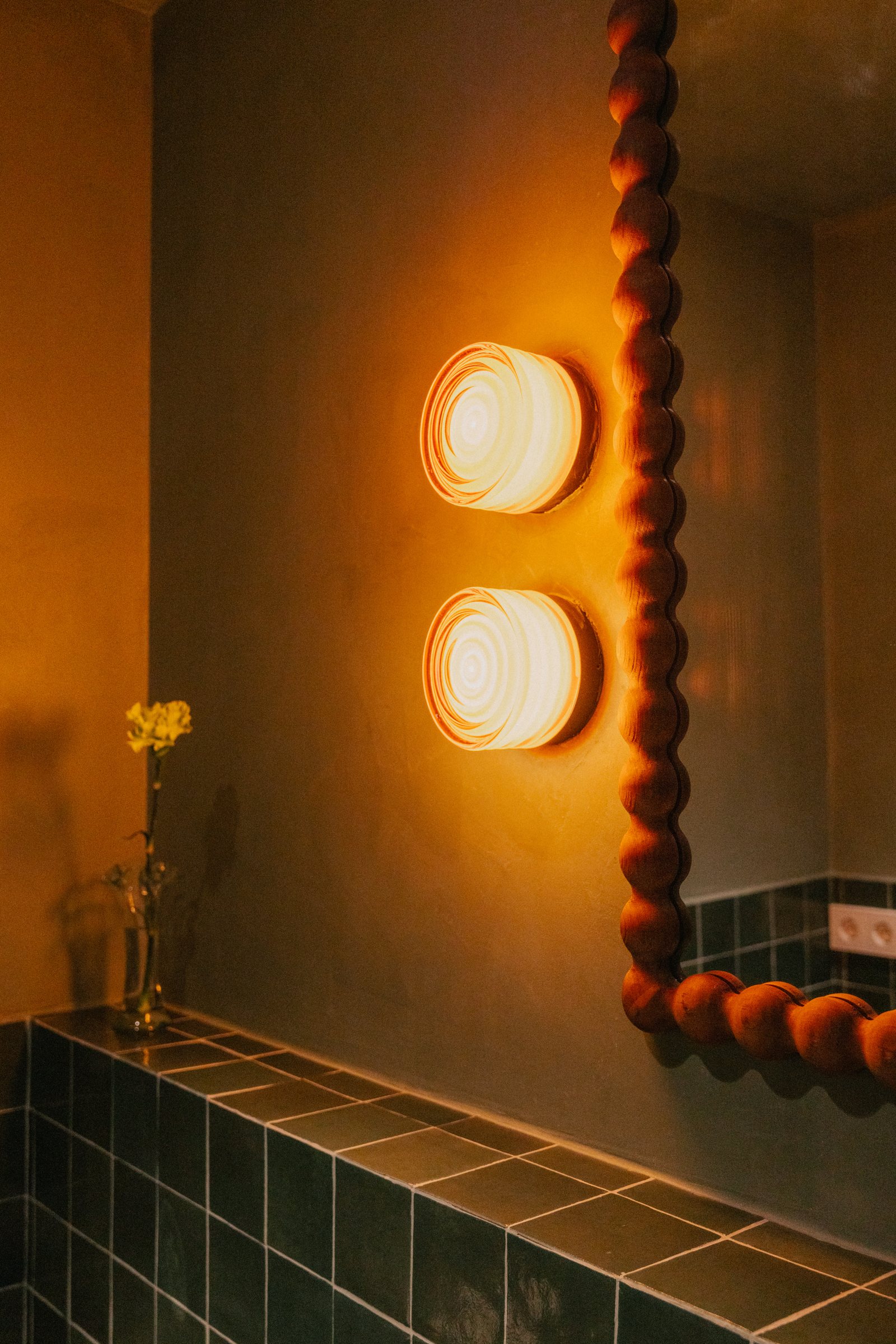 Casa Manila — Aseo con apliques de luz cálida y espejo de madera torneada
